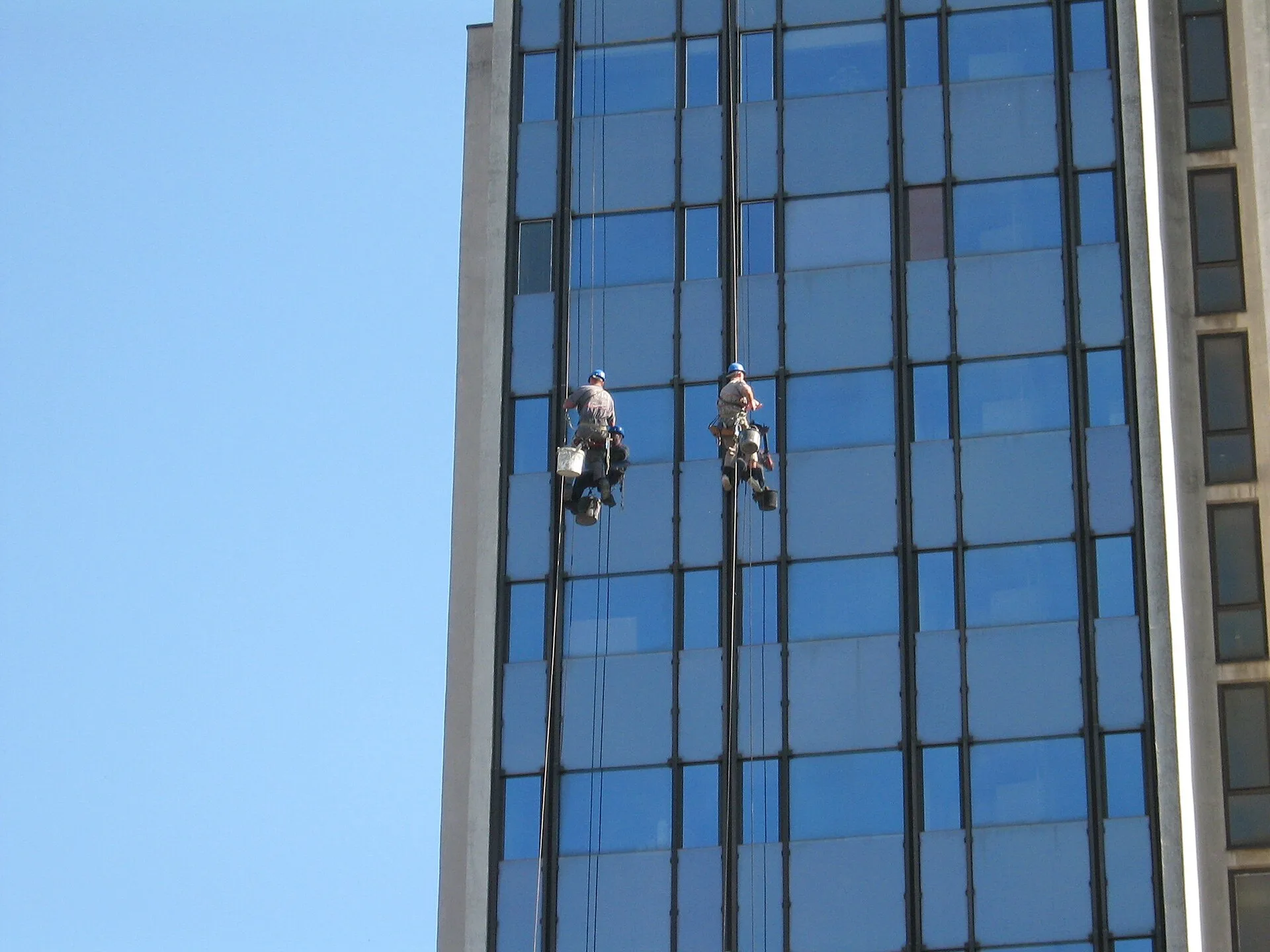 Window cleaners on the face of the post office building in Pančevo /Čistači prozora na zgradi Pošte u Pančevu. Pricing window cleaning in Canadian dollars, Toronto, Calgary and Halifax compared