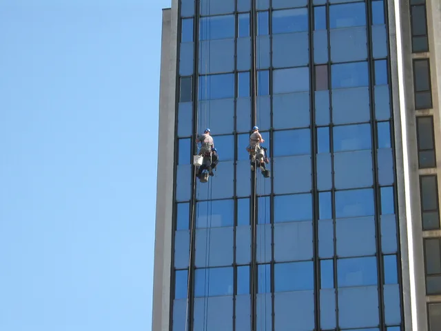 Window cleaners on the face of the post office building in Pančevo /Čistači prozora na zgradi Pošte u Pančevu. Pricing window cleaning in Canadian dollars, Toronto, Calgary and Halifax compared